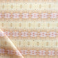 A close up of Setting Sun Fabric with a light terracotta and beige pattern.
