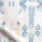 A close up of Splash Fabric Cerulean, a blue and white fabric with a floral pattern that seems to have been watercolor printed