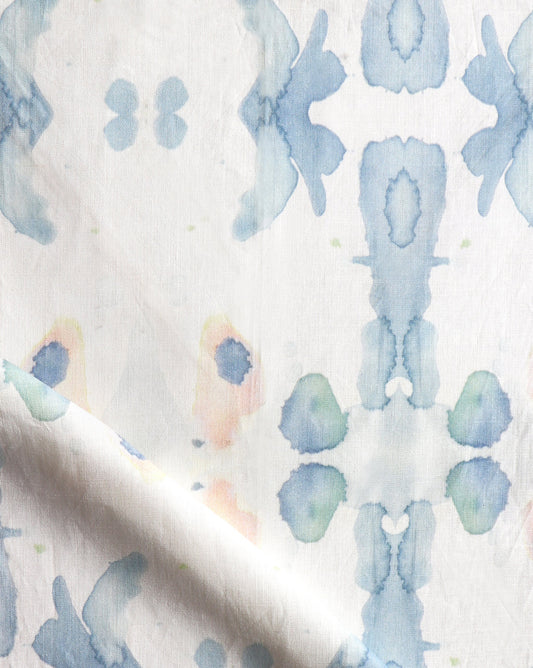 A close up of Splash Fabric Cerulean, a blue and white fabric with a floral pattern that seems to have been watercolor printed