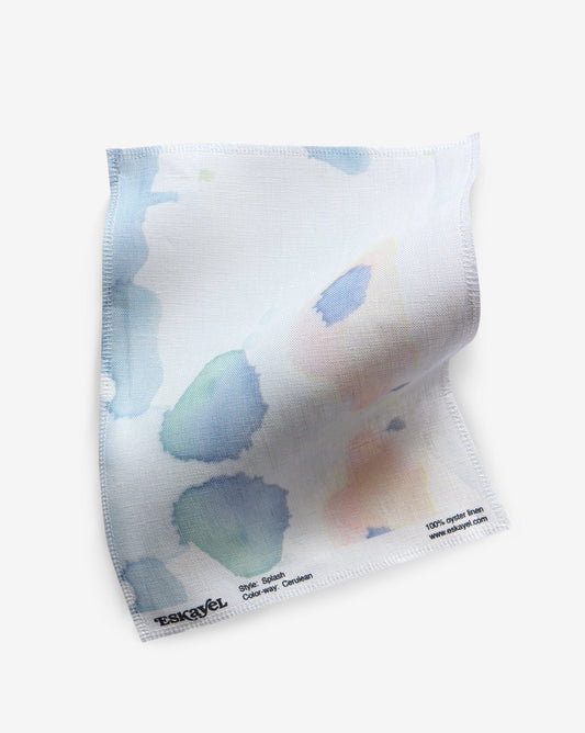 a sample of the Splash Fabric Sample Cerulean with watercolor splatters on it