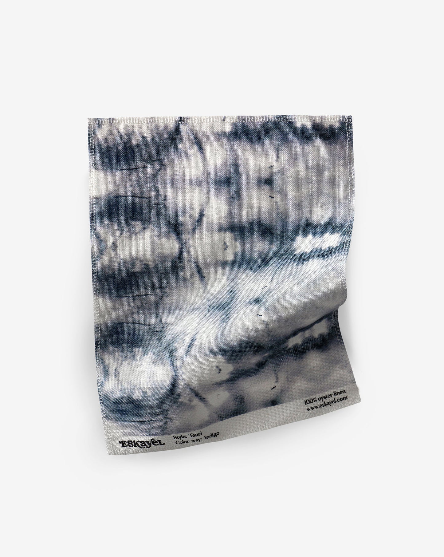 A blue and white tie dye pattern on a white background, crafted from Tauri Fabric Indigo