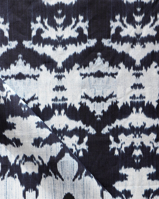A close up of a blue and white The Dance Fabric Indigo Ikat fabric from the Lora Collection