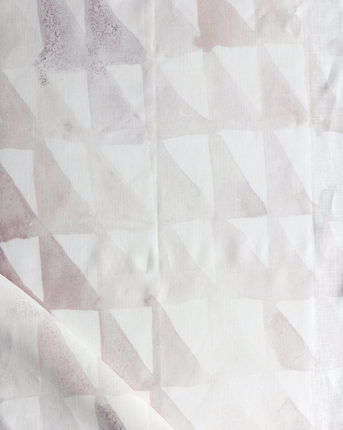A close up of a white and pink Triangle Checks Fabric with triangles on it in the Sol colorway