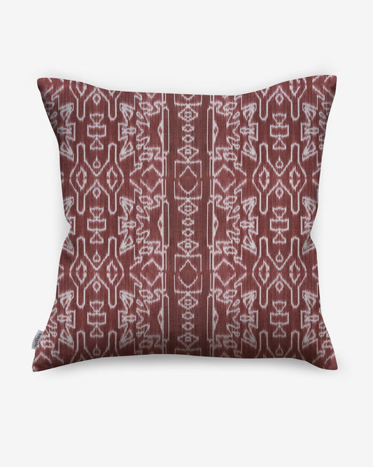 A red and white Akimbo Pillow with a geometric pattern featuring Morinda Ikat.