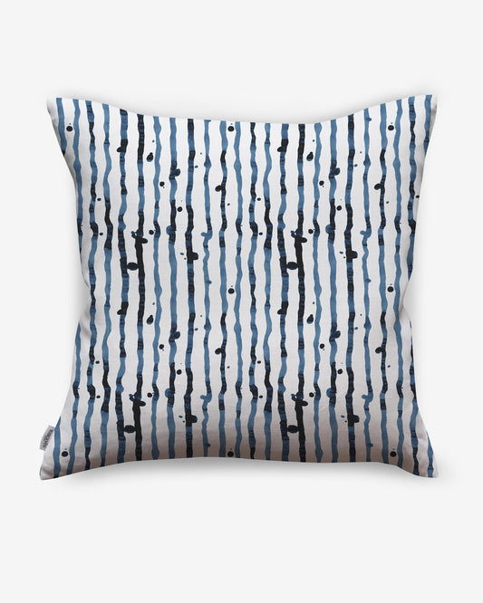 A pillow with a blue and black Drippy Stripe Pillow Azure pattern on it