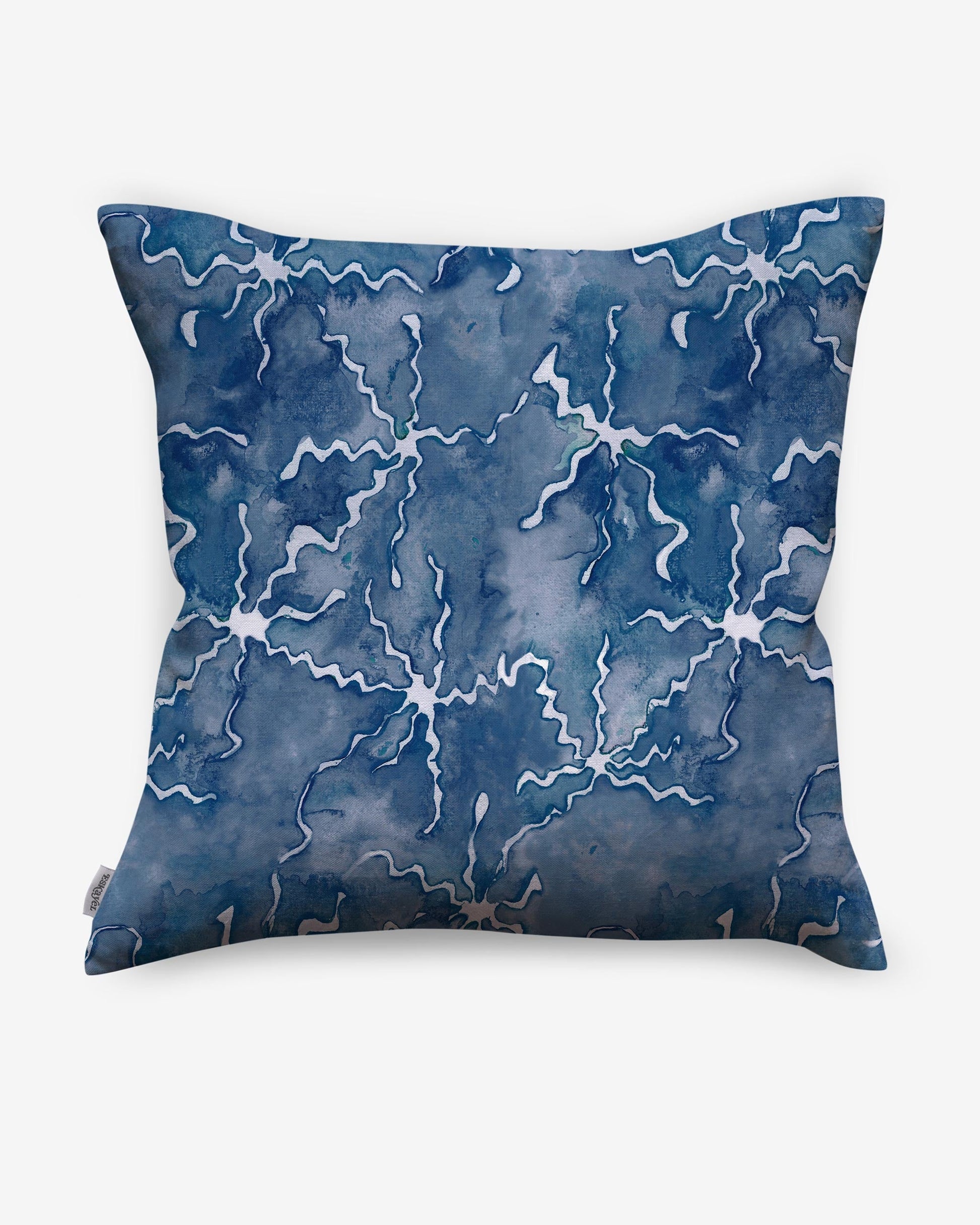 A Nuit pillow with a blue and white pattern on it using resist dye techniques