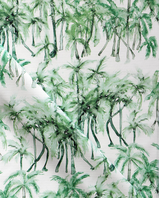 A green and white fabric with palm trees, a watercolor pattern and Palm Dance Performance Fabric Chloros