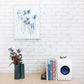 A white bookcase with So Cal Print artworks and a vase of flowers