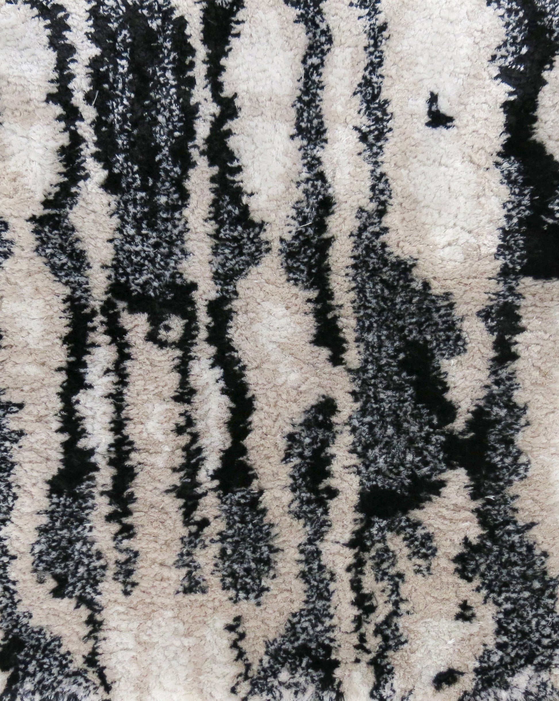 A close up image of a tactile Biami Hand Knotted Rug Black with a Biami pattern