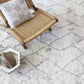 A grey Peaks Hand Knotted rug with a wicker chair on it