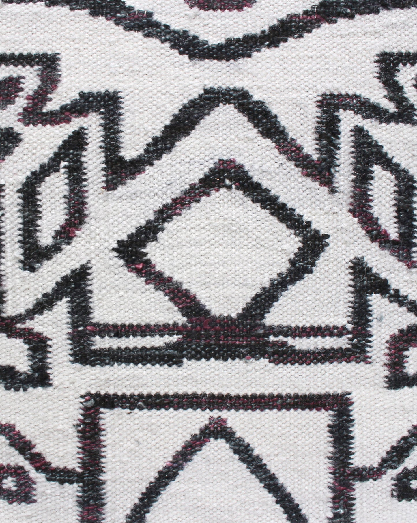 A close up of the Akimbo 5 Flatweave Rug Black And White with a geometric design