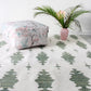 An Areca Palms flatweave rug with a pink flower and a potted plant, featuring the Chloros colorway