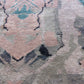 A close up of a Tamandot Hand Knotted Rug Duomo with an abstract pink, blue, and green design