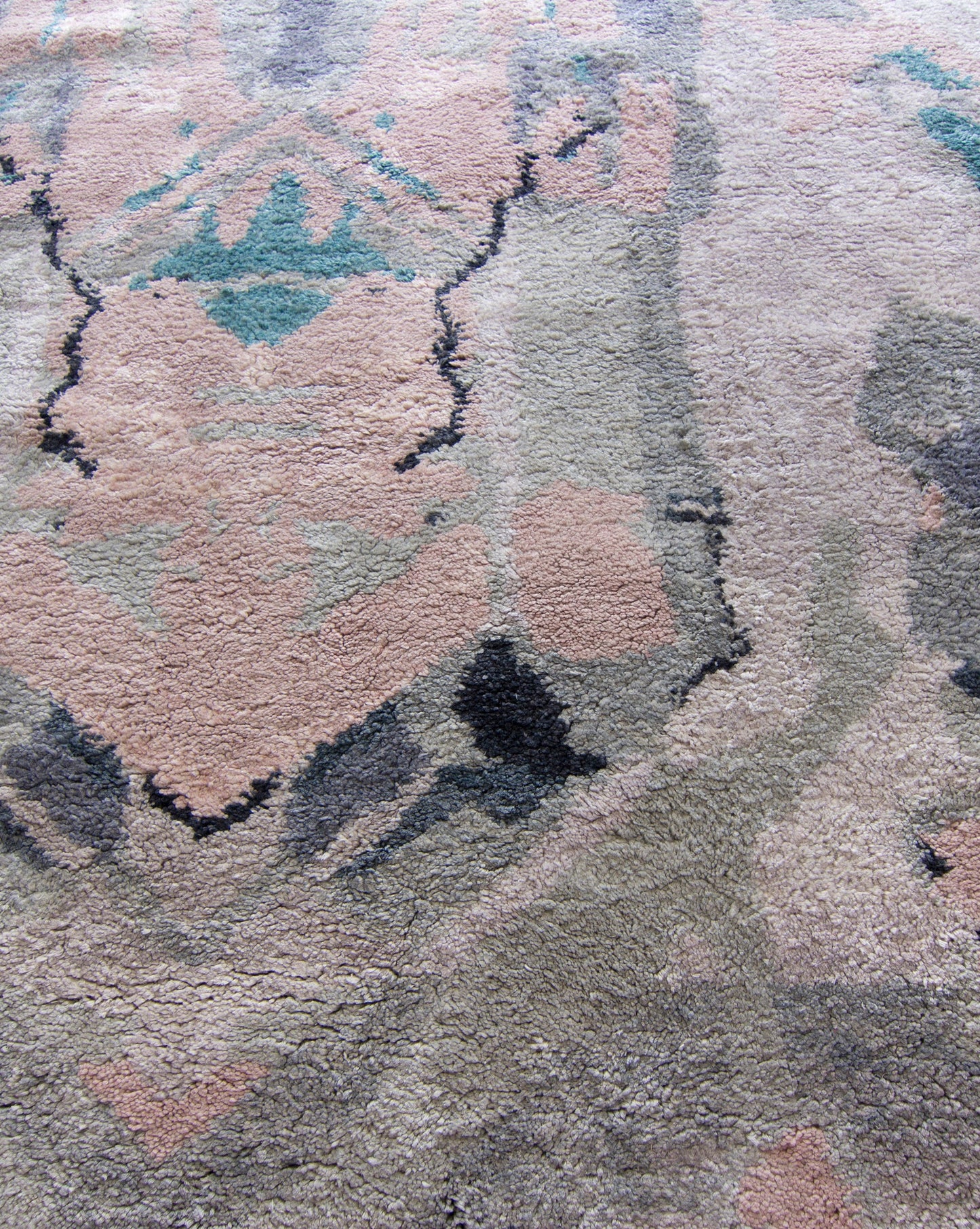 A close up of a Tamandot Hand Knotted Rug Duomo with an abstract pink, blue, and green design