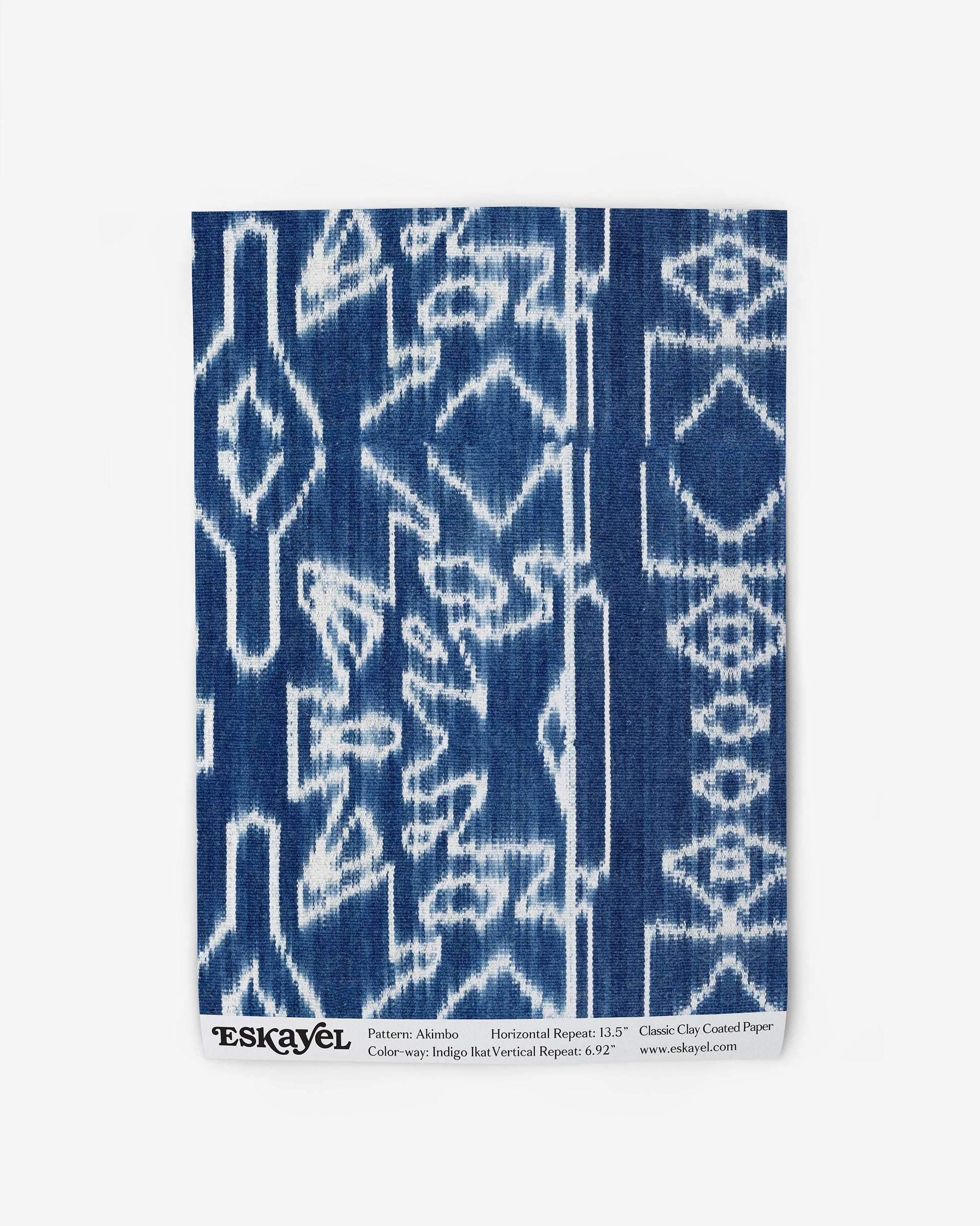 A blue and white Akimbo Wallpaper Indigo Ikat print with a graphic geometric pattern on wallpaper