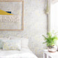 A bed in a room with Stele Wallpaper Citrus patterned fabric