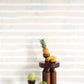 A table with fruit on it from the Bold Stripe Wallpaper Sand Collection by Eskayel