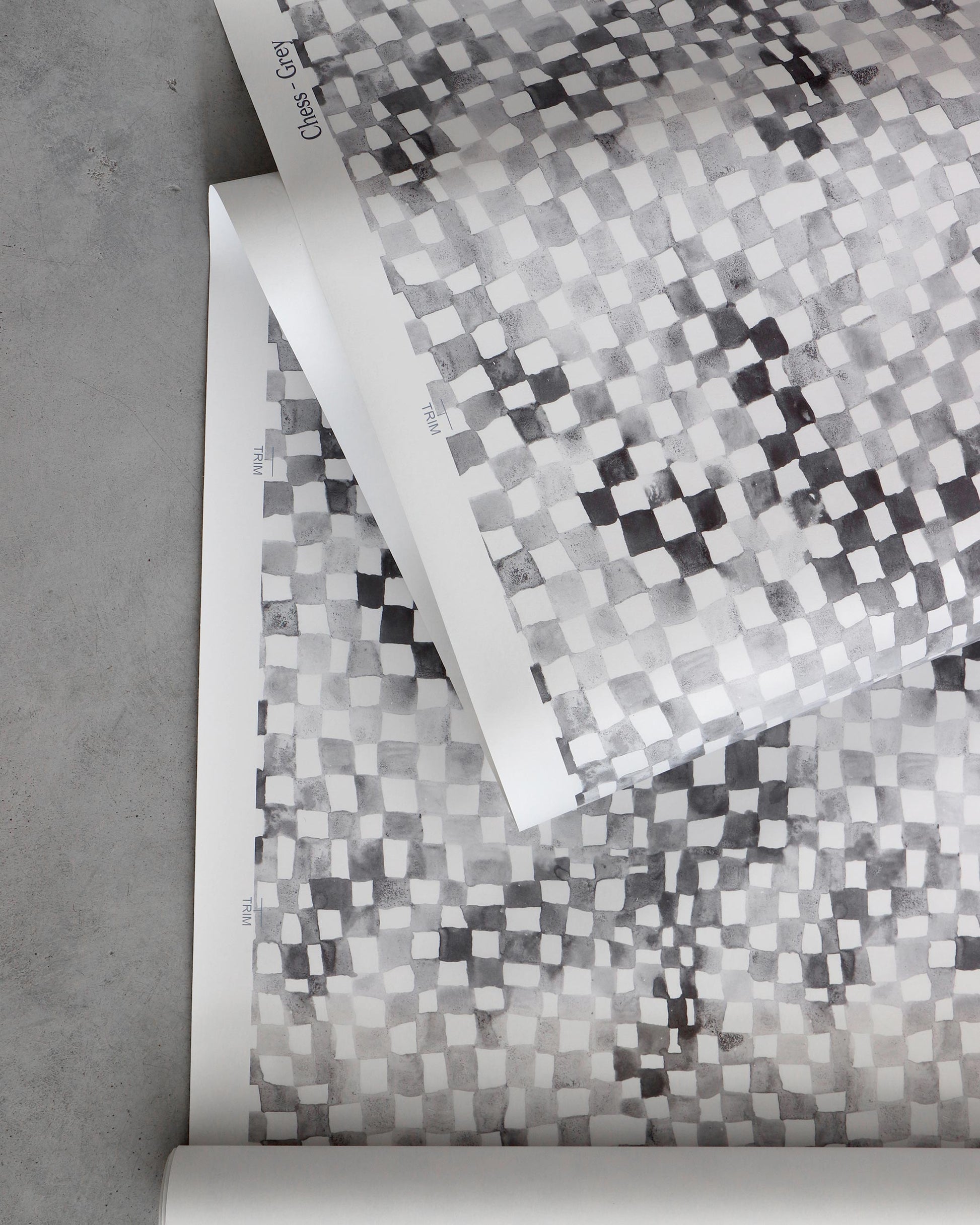 A roll of Chess Wallpaper Grey with a checkerboard pattern on it