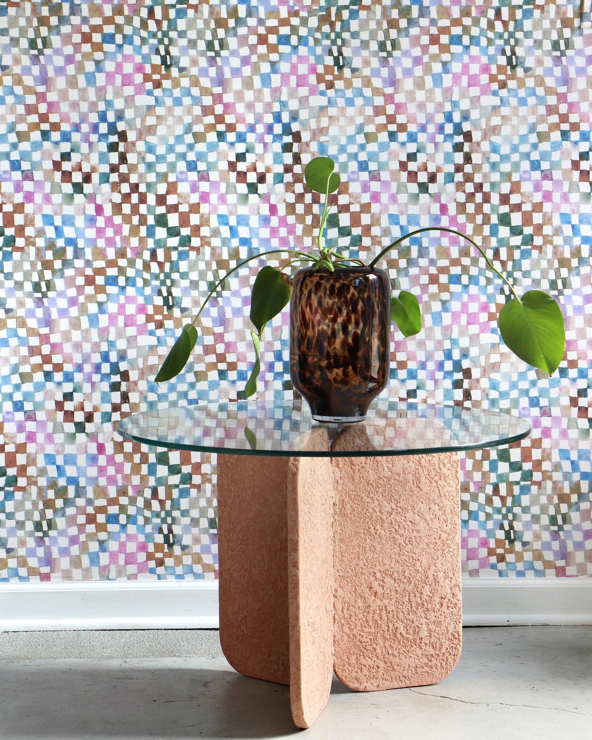 A table with a potted plant in front of a Chess Wallpaper Multi high-end checkerboard pattern