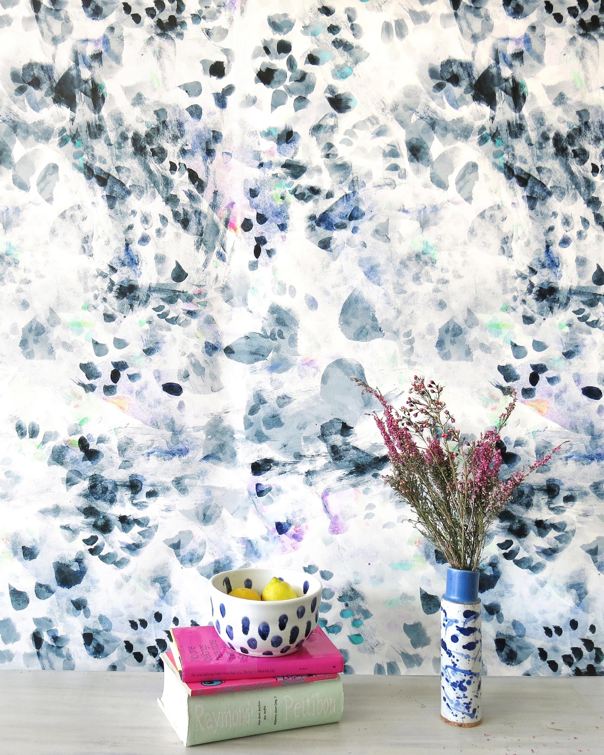 A vase of flowers on a table next to Felidae Wallpaper Flint