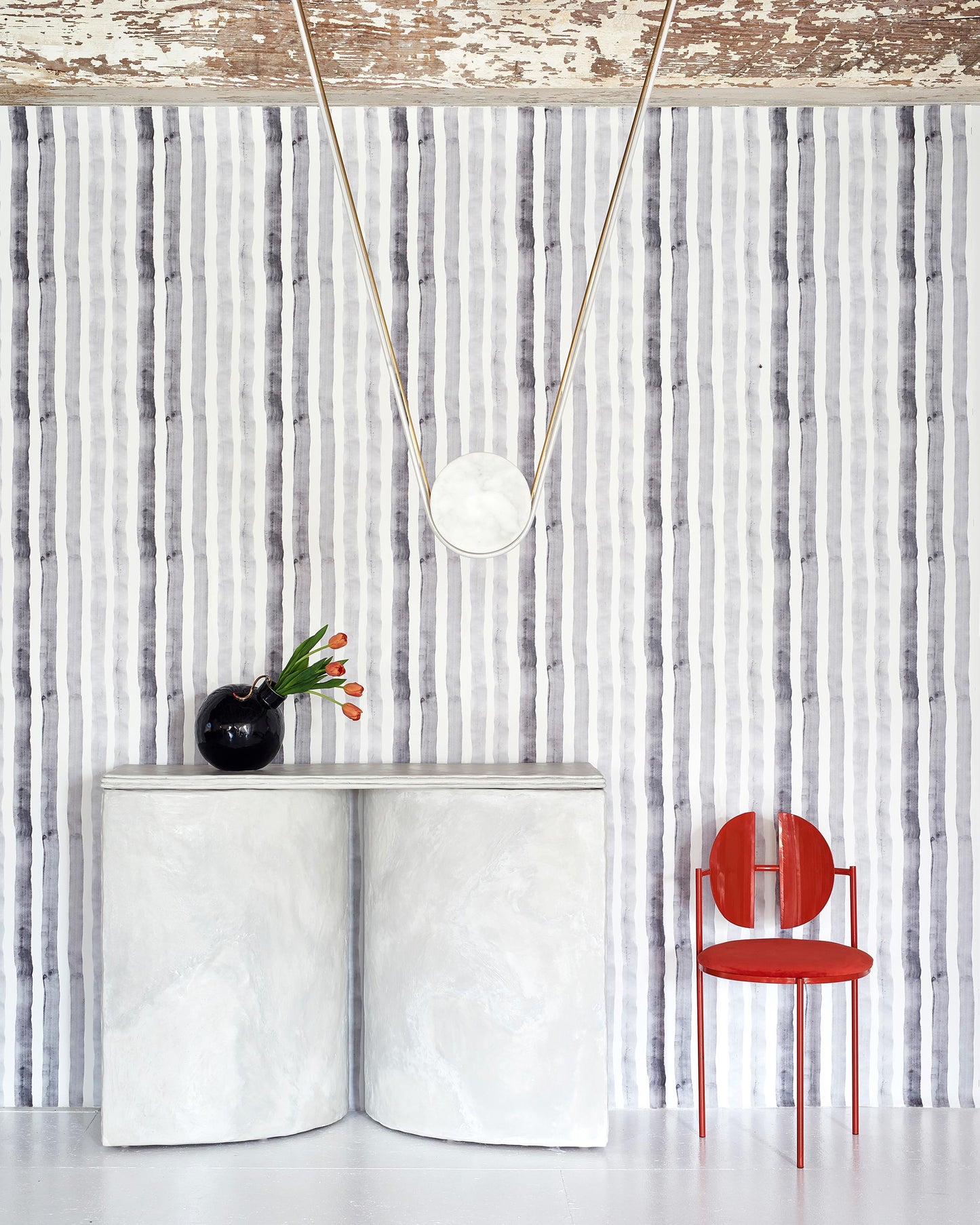 A room with a red chair and a white table made of Gradient Stripe Wallpaper Slate