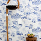A blue and white Out East Wallpaper Cobalt pattern fabric in front of a wooden stool