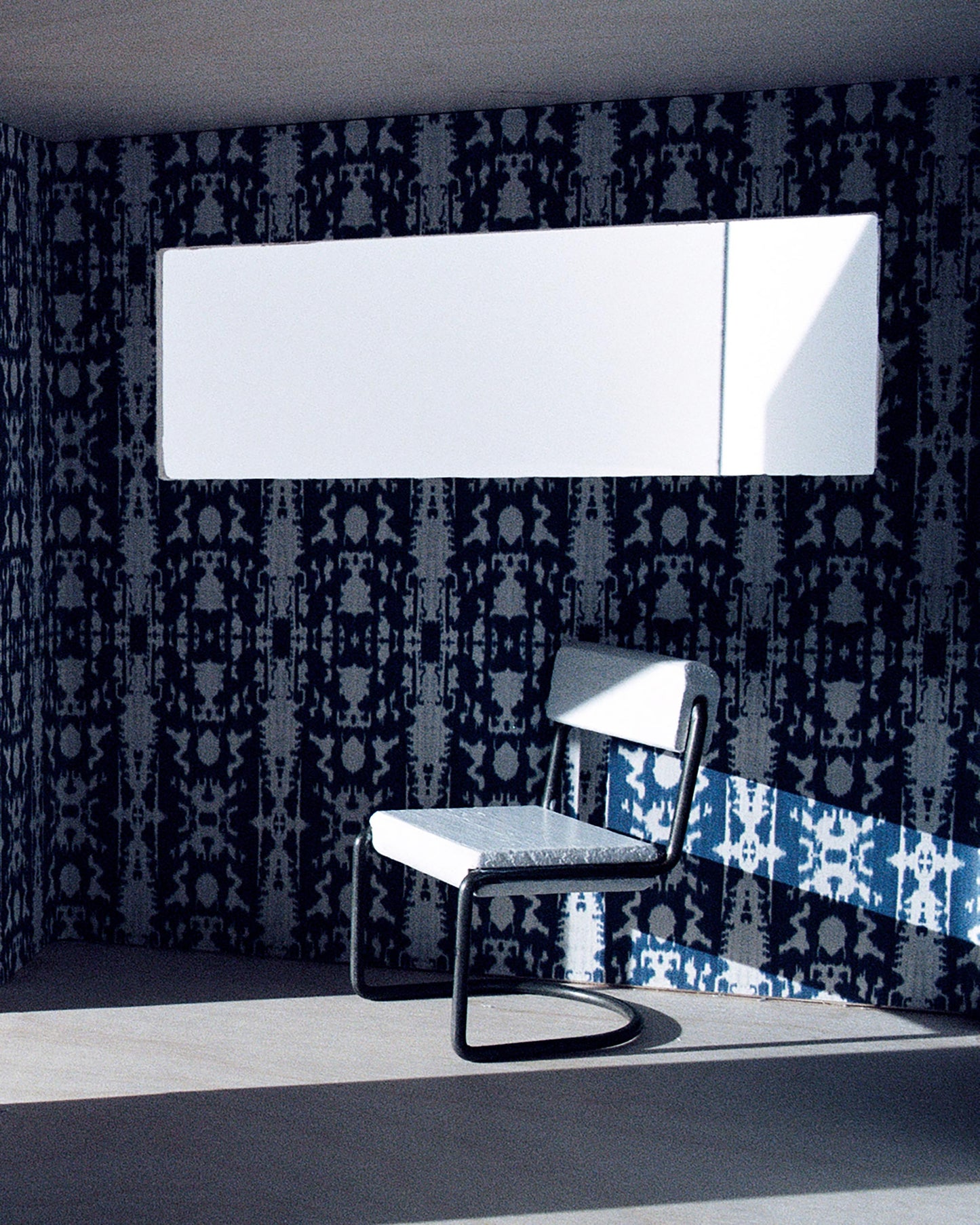 A chair in a room with high-end fabric and Biami Wallpaper Indigo Ikat