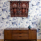 A luxurious, high-end Cherifia Wallpaper adorns the room, complementing the wooden dresser