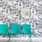 Two teal chairs in front of a wall with a floral pattern adorned with custom wallpaper from the Clemente Wallpaper||Canyon.