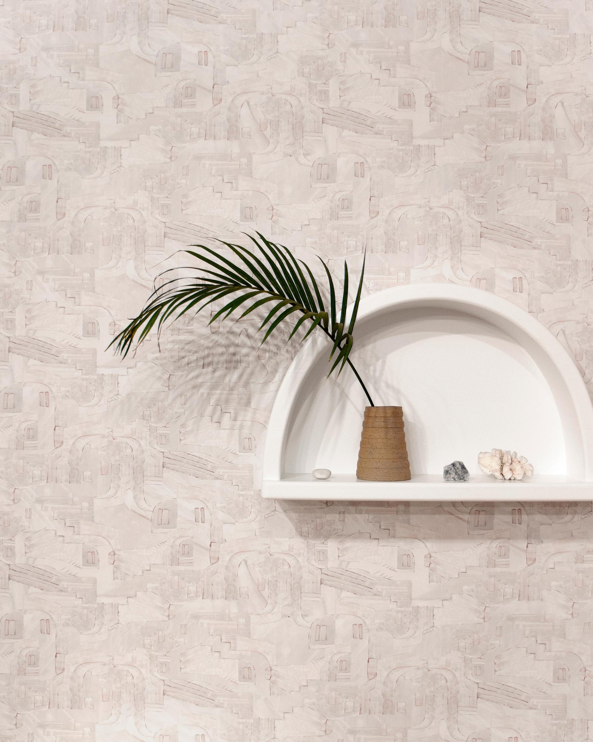 A shelf with a plant and La Scala Wallpaper Shell on it on a white wall