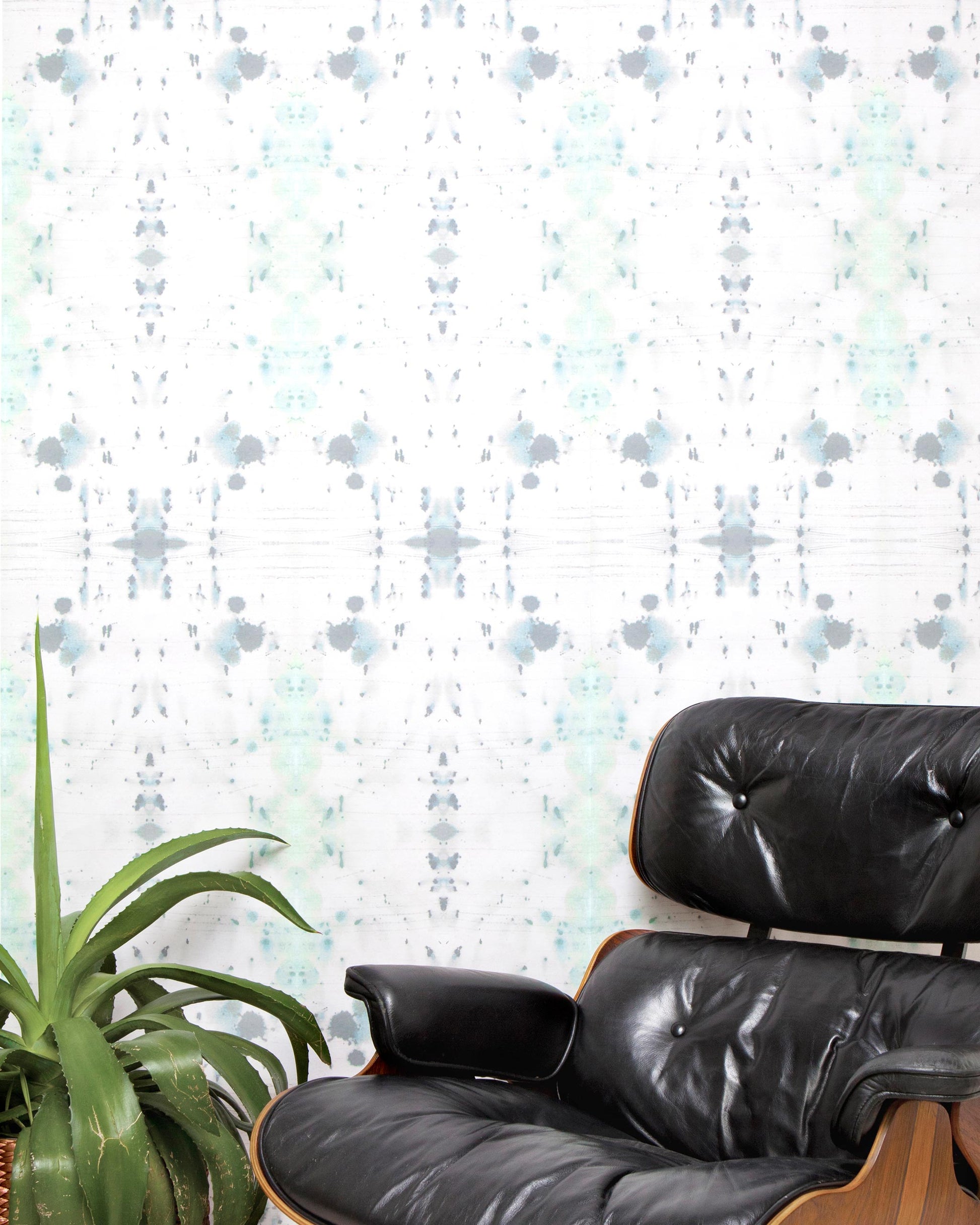 A black leather chair in front of a Nairutya Wallpaper Nyanza