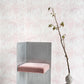 A pink chair sits in front of Palm Dance Wallpaper Coral