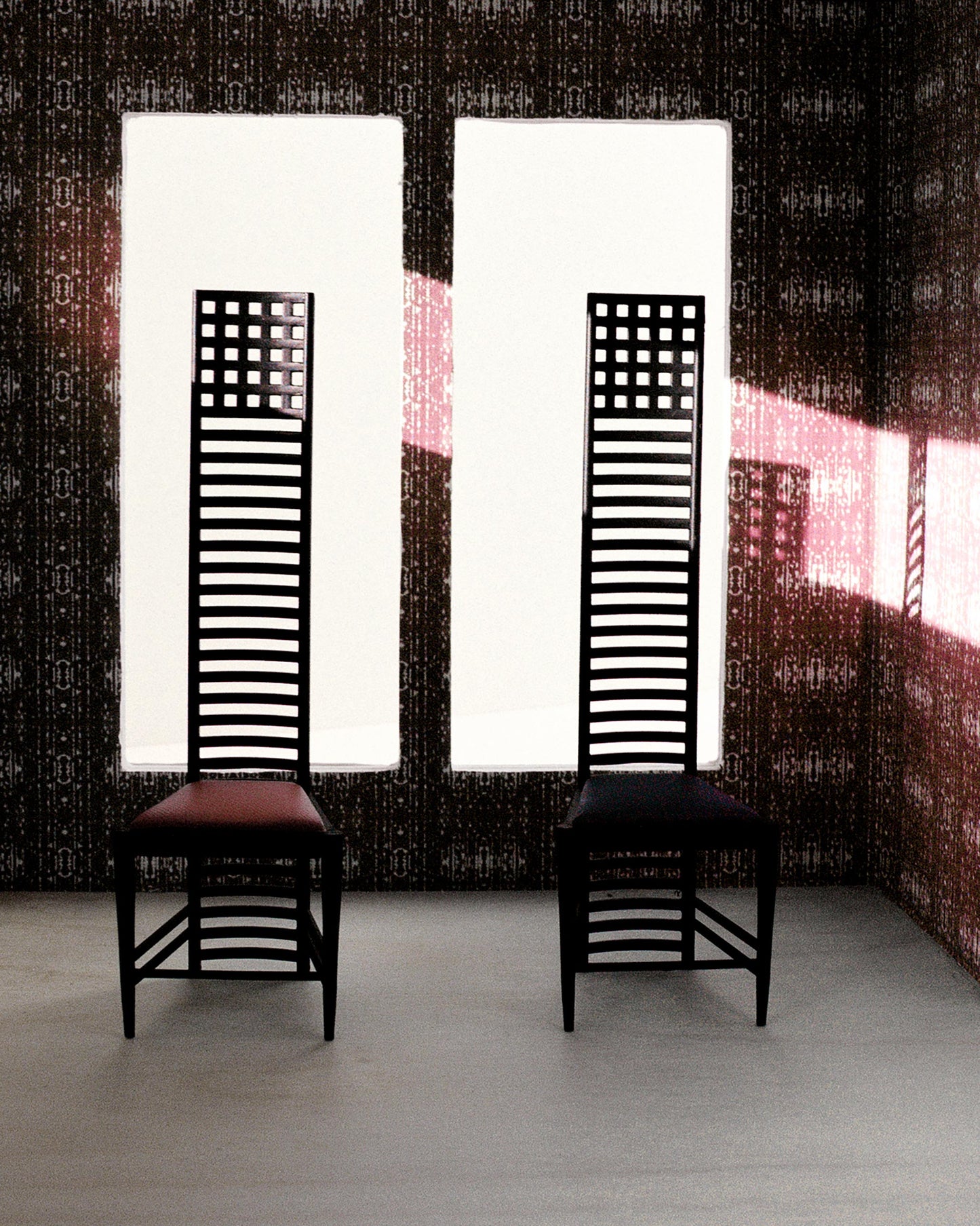 Two chairs in front of a window with Eskayel's high-end Omaha Kinship wallpapers showcasing the Morinda Ikat colorway