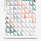A roll of Triangle Checks Wallpaper||Reef with a watercolor pattern in the Triangle Checks colorway.