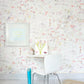 A child's room with a pink and white Vol de Nuit Wallpaper Sunshine