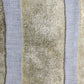 Four strips of beige wool in a bold stripe on a blue background